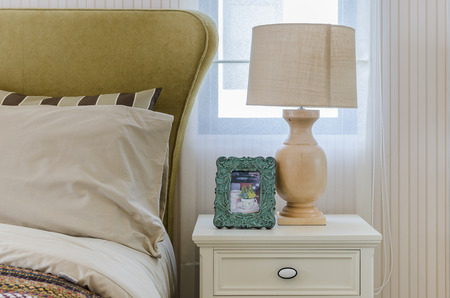 lamp and frame on table side in bedroom at homeの写真素材