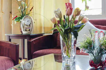 living room with red fabric sofa and flower in glass vaseの写真素材