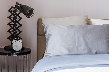 modern bedroom with modern lamp and alarm clock at home