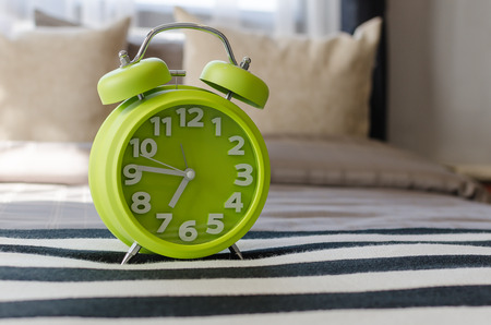 modern green alarm clock on bedの写真素材