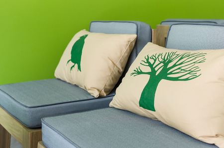 modern wooden chairs with pillows and green wallの写真素材