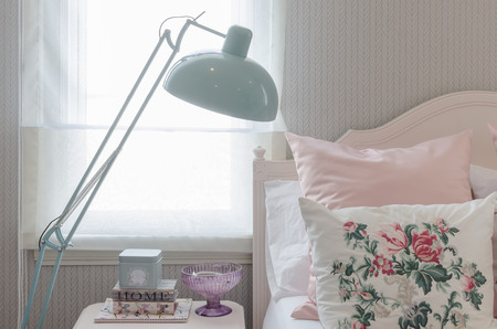 pink pillows on bed in bedroom with green lamp at homeの写真素材