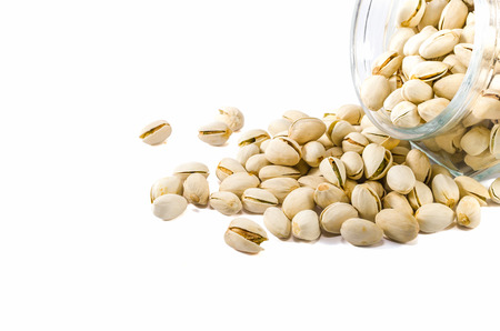Pistachio nuts in glass bowl isolated on white  backgroundの写真素材