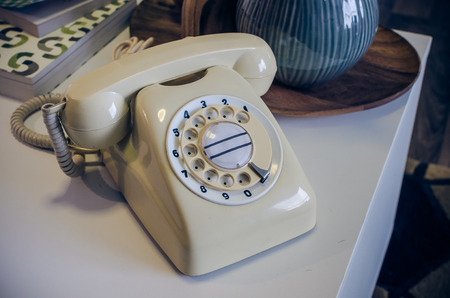 Retro photo of classic telephone on white deskの写真素材