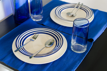 table setting with blue theme for couple on black tableの写真素材