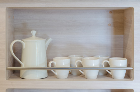 teapot and cups on wooden shelfの写真素材