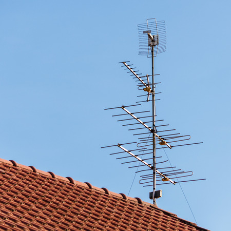 television antenna  on roof with blue skyの写真素材