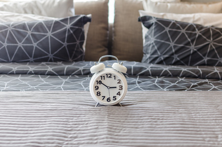 white alarm clock in bedroom at homeの写真素材
