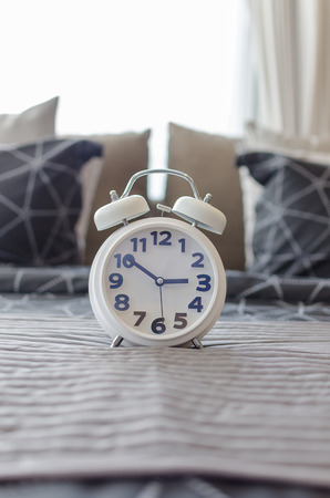 white modern alarm clock in bedroomの写真素材