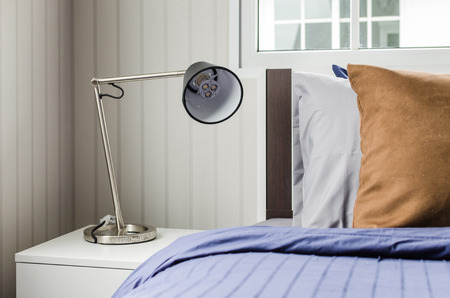 modern lamp on white nightstand in single bedroom at homeの写真素材