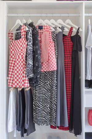 white closet with shirt and dress hanging at homeの写真素材