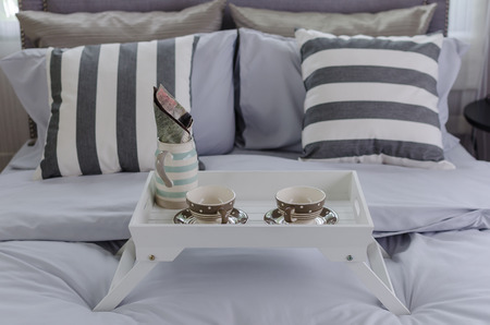 tea cup set on white tray on bed in bedroom at homeの写真素材