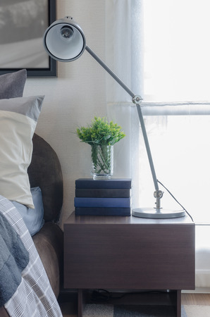 modern lamp on wooden table in bedroom at homeの写真素材
