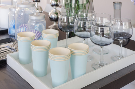 row of paper cups and glass on white trayの写真素材