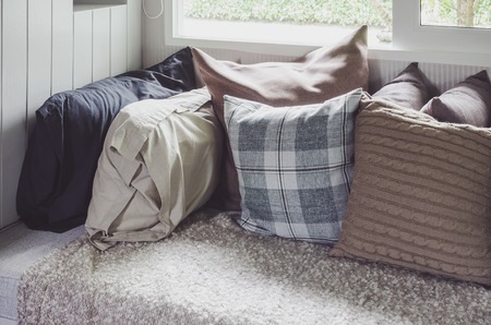 many of pillows on sofa with blanket in living room at home - vintage style effect picture