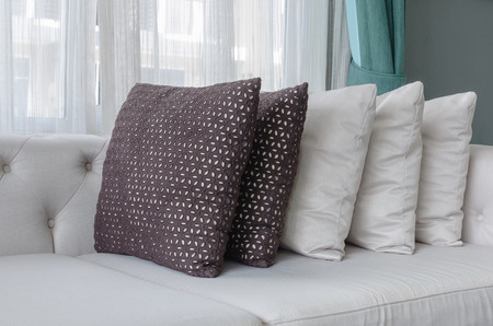 row of pillows on white modern sofa in living room at home