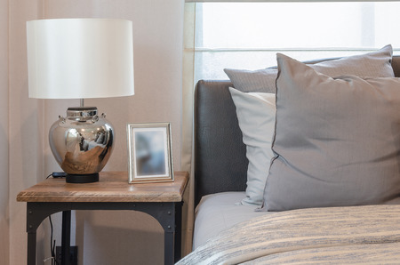classic lamp style on wooden table with pillows on bed at homeの写真素材