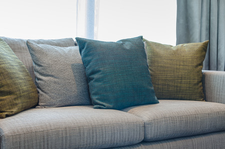 group of fabric pillows on fabric sofa in living room at homeの写真素材