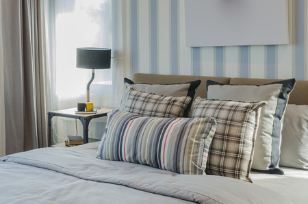 retro style pillows on bed in modern bedroom with sunlight at home