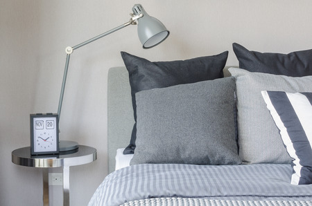 modern grey lamp with alarm clock on side table in bedroom at homeの写真素材