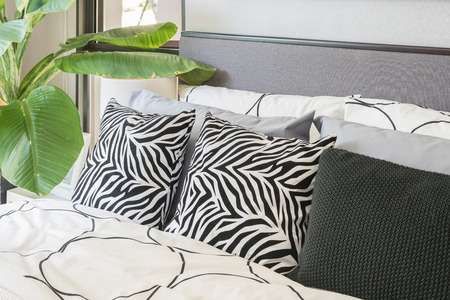 black and white pillows and blanket on modern bed at home