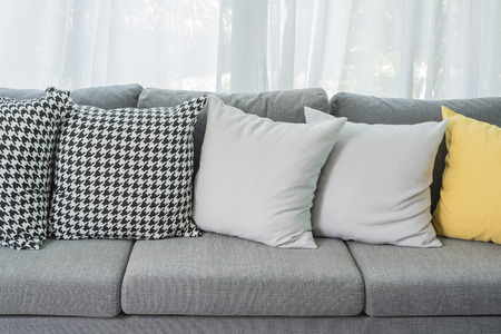 yellow and grey pillows on modern sofa in living roomの写真素材