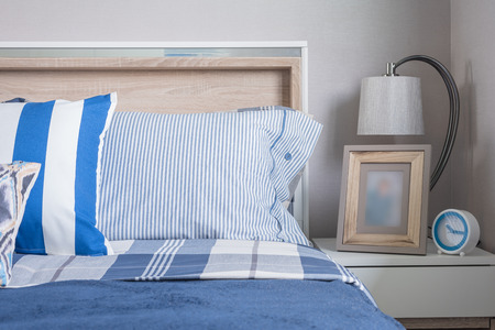 blue color tone of kid's bedroom with alarm clock and lamp on tableの写真素材