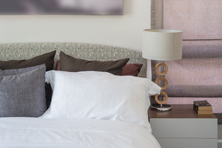 white pillow in modern bedroom with white lamp on table at homeの写真素材