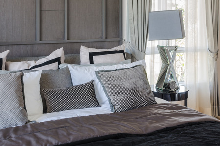 luxury bedroom in dark color tone style with lamp and alarm clock on table side at homeの写真素材