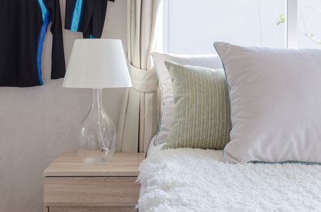 modern glass lamp on wooden side table in bedroom at homeの写真素材
