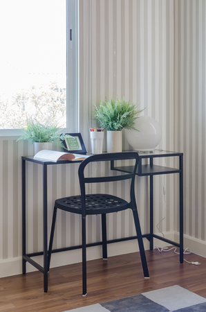 working room with black table and chair with vase of plantsの写真素材