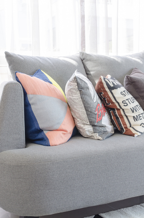 colorful pillows on modern grey sofa in living roomの写真素材