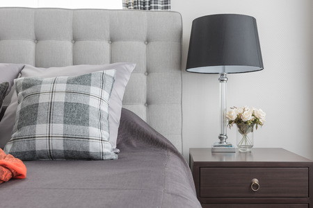 classic lamp style with vase of flower on wooden bedside table in classic bedroom
