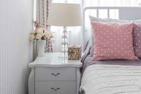 classic white lamp style with vase of flower on wooden grey table bedside in bedroomの写真素材