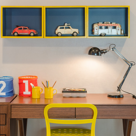 yellow chair and wooden desk with modern black lamp in kid's bedroomの写真素材