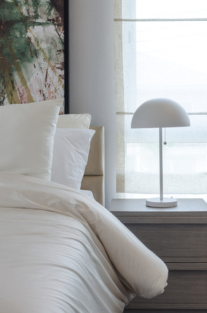 modern white lamp on wooden table side in modern bedroomの写真素材