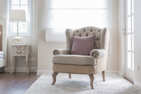 classic chair on carpet with pillow in bedroomの写真素材