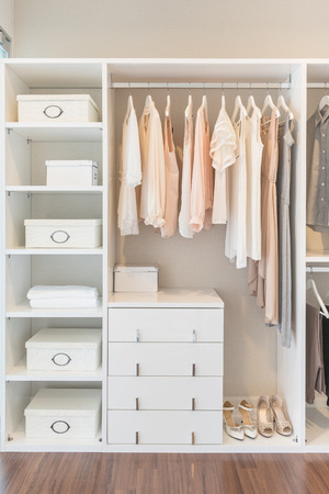 white wardrobe on wooden floor with dress hanging on railの写真素材