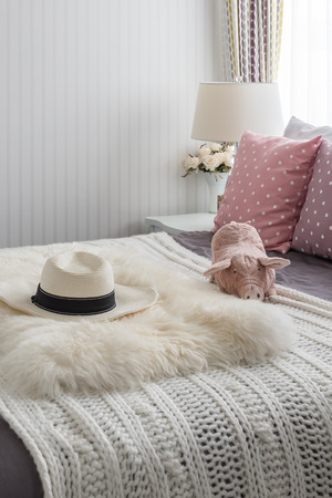 pink pillows with pink doll on white wooden bed and classic hat in bedroomの写真素材
