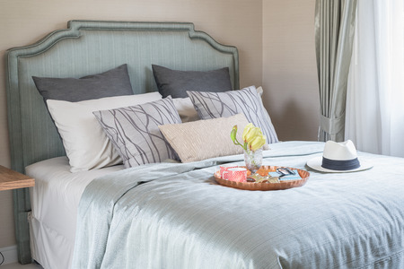 hat and tray with glass vase flower on bed in luxury bedroomの写真素材