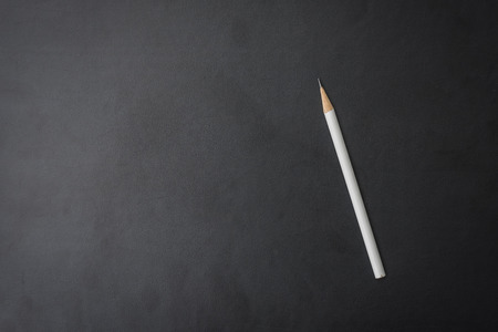 white pencil on black backgroundの写真素材