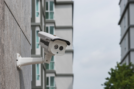 dirty CCTV security camera on stone wall