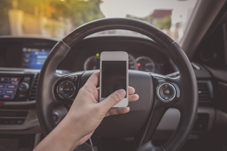 driver using white touch screen smartphone in car - vintage picture styleの写真素材
