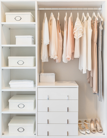 white wardrobe on wooden floor with dress hanging on railの写真素材