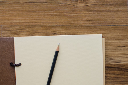 blank notebook with pencil on wooden tableの写真素材