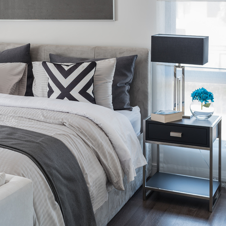 modern bedroom with white bed and black lamp on table sideの写真素材