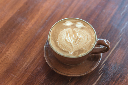 cup of latte coffee on wooden table in coffee shopの写真素材