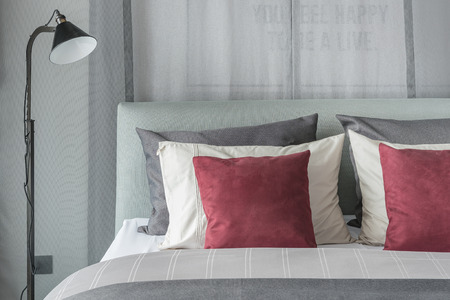 black lamp  in modern bedroom design with red pillows on bedの写真素材