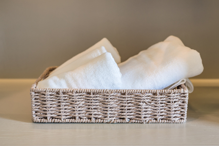 white towels in basket on wooden wardorbeの写真素材