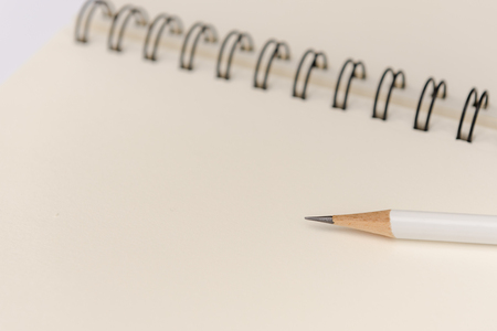 white pencil with blank notebook on white backgroundの写真素材